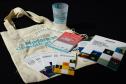 Materiais gráficos e ecobag distribuídos durante o evento do Fórum.