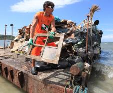 Homens contratados pelo Instituto das Águas do Paraná retiram lixo produzido por moradores de Encantadas, na Ilha do Mel, Litoral Paranaense