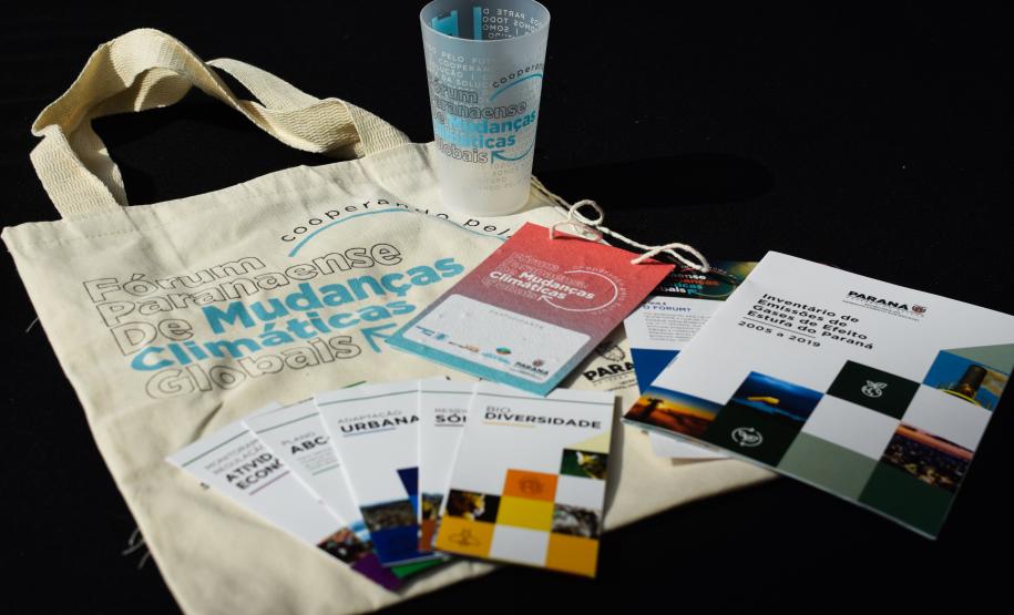 Materiais gráficos e ecobag distribuídos durante o evento do Fórum.