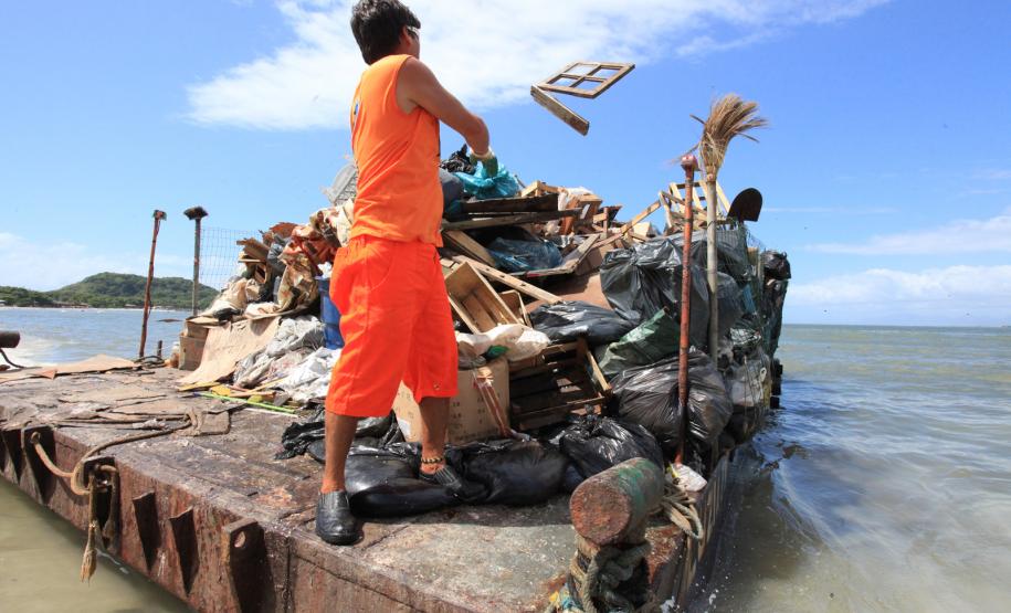 Homens contratados pelo Instituto das Águas do Paraná retiram lixo produzido por moradores de Encantadas, na Ilha do Mel, Litoral Paranaense