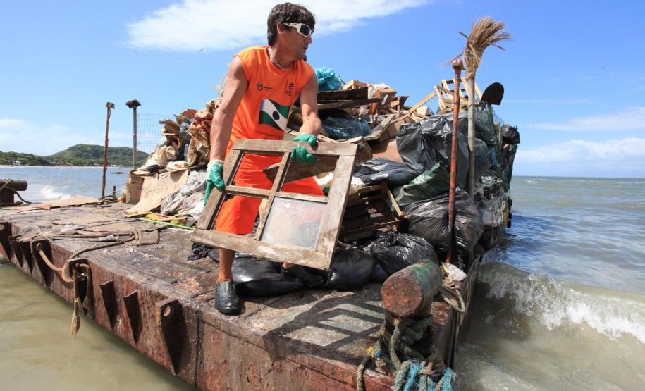 Homens contratados pelo Instituto das Águas do Paraná retiram lixo produzido por moradores de Encantadas, na Ilha do Mel, Litoral Paranaense
